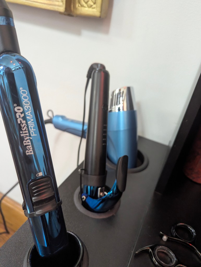 two hot tools and a blow dryer in a stylist station
